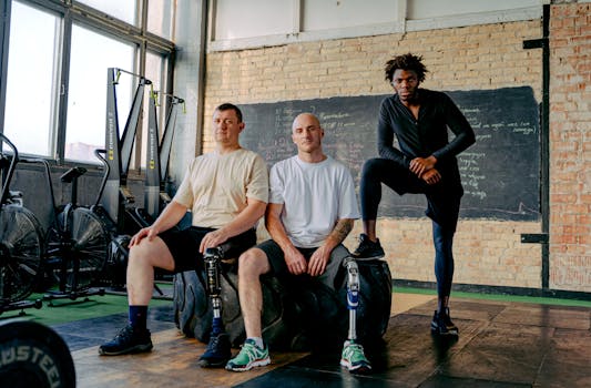 Diverse group of men with prosthetic legs posing confidently in a gym setting, showcasing strength and inclusivity.