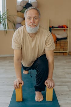Senior man practicing yoga using blocks indoors for a healthy lifestyle.
