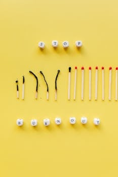 A conceptual photo depicting burnout with matches and dice on a yellow background.