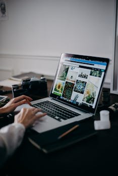 A creative workspace featuring a laptop displaying a gallery of images, ideal for digital nomads and remote work.