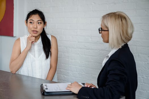 A professional discussion between two women in an office setting.