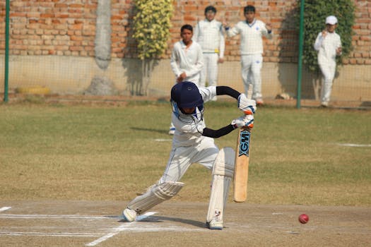 A young cricket player bats during a game on a sunny day in Gurugram, India.