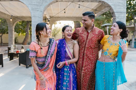Four people in traditional clothing share a joyous moment outdoors