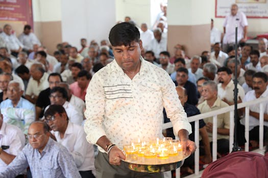 Man holding candles in community gathering for religious ceremony.
